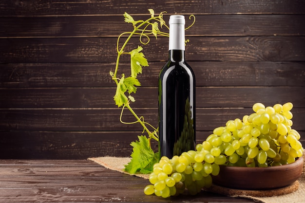 Wine bottle and grape on wooden table