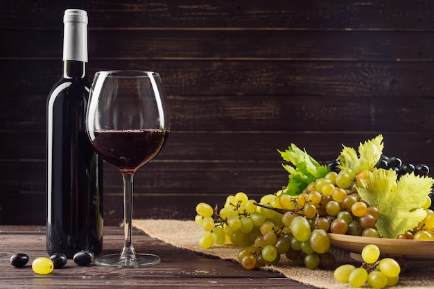 Wine bottle and grape on wooden table