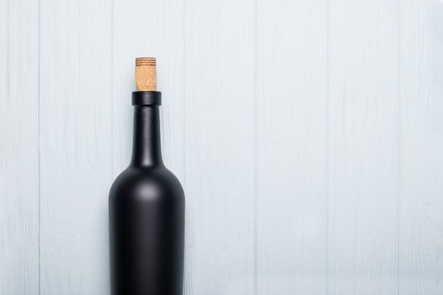 Wine bottle on white wooden background.