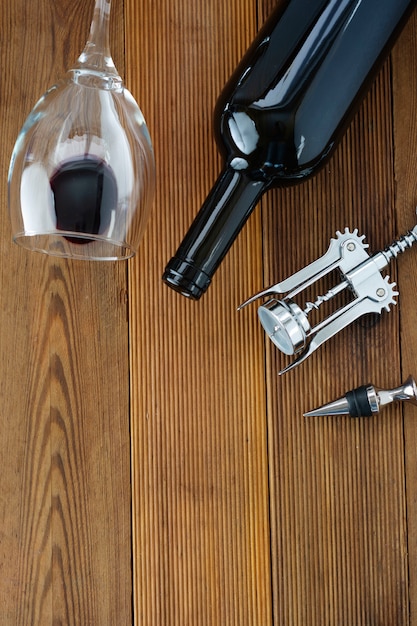 Wine bottle with wineglass corckscrew rustic wooden board, copyspace. Flat lay.