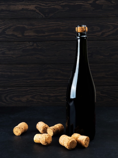 Бутылка вина на деревянный пол и гранж, рядом пробка, мишура