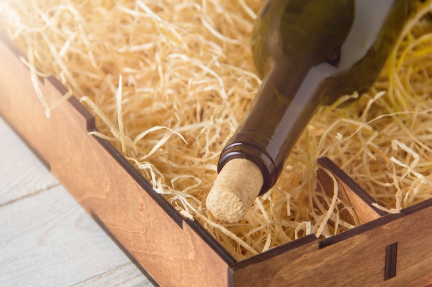 Foto bottiglia di vino in scatola di legno