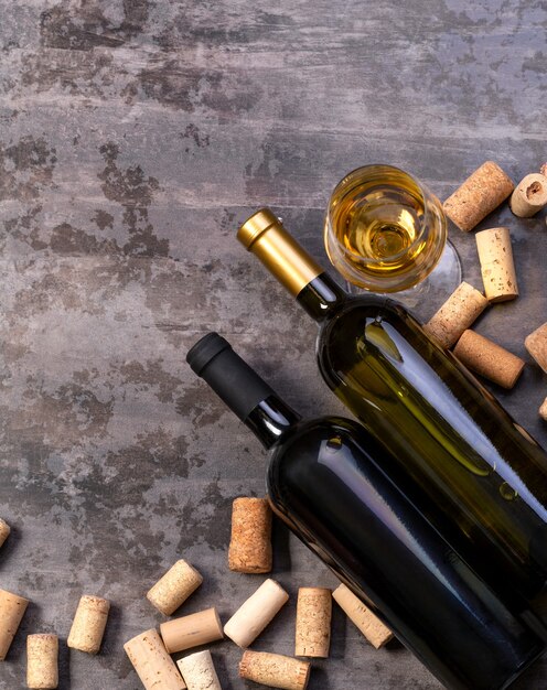 Wine bottles and corks on dark table, top wiev