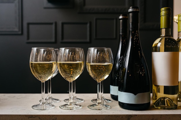 Wine bottles and glasses with white and rose wine on bar counter