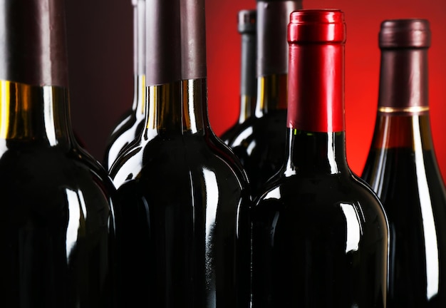 Foto bottiglie di vino su sfondo rosso