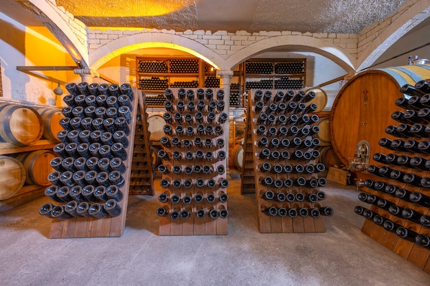 Photo wine cellar with barrels and bottles