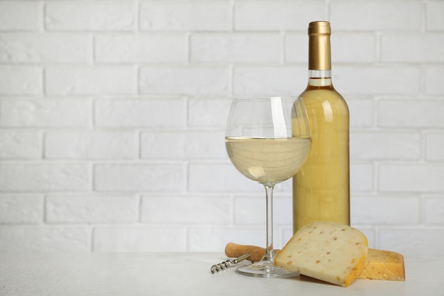 レンガの壁の背景にワインとチーズ