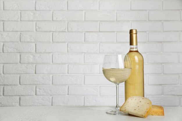 Wine and cheese on brick wall background