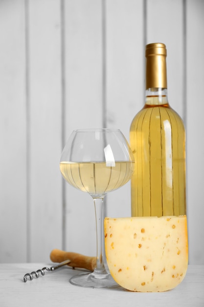 Vino e formaggio sul fondo della parete di legno