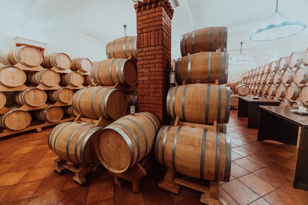 Wine or cognac barrels in the cellar of the winery, Wooden wine barrels in perspective. Wine vaults.Vintage oak barrels of craft beer or brandy.