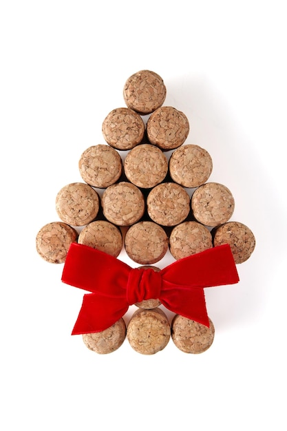 Photo wine corks in the shape of a herringbone with a red bow isolated on a white background