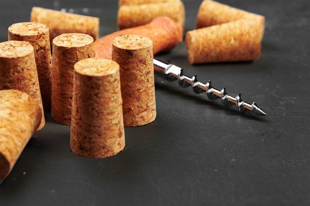 Wine corks with corkscrew on wooden table