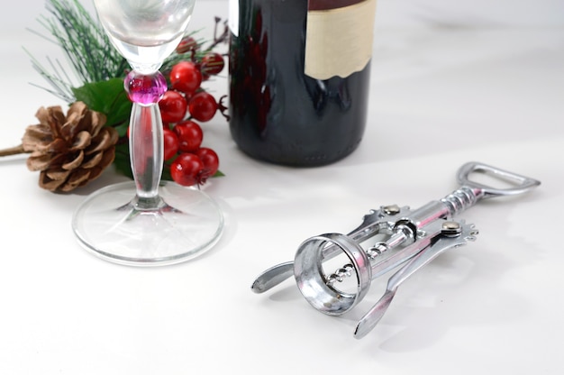 Photo wine corkscrew glass and christmas branch