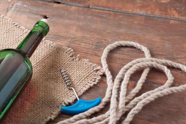 Wine and corkscrew on the wooden table.