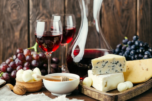 Wine and different cheese on wood