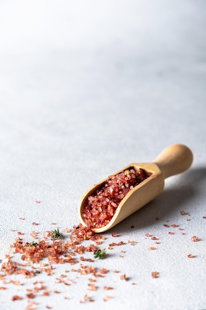 Wine flavored salt in wooden scoop on a gray background