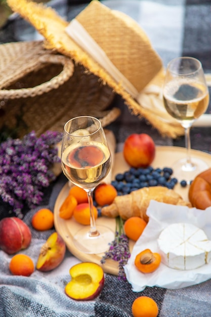 Wine fruits berries cheese glasses picnic in lavender field Selective focus