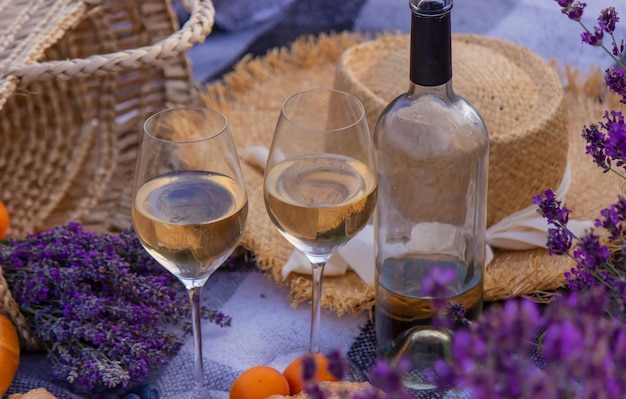 Wine fruits berries cheese glasses picnic in lavender field Selective focus