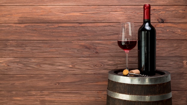 Wine glass and bottle on a barrel