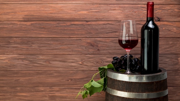 Photo wine glass and bottle on a barrel