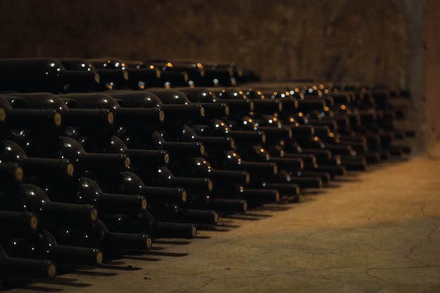 Bottiglie di vetro di vino che fermentano in cantina.