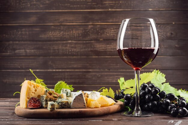 Bicchiere di vino e grappolo d'uva sul tavolo di legno