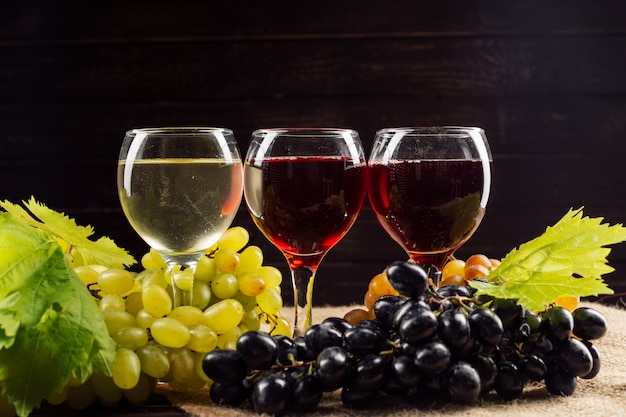 Bicchiere da vino e grappolo d'uva sul tavolo di legno