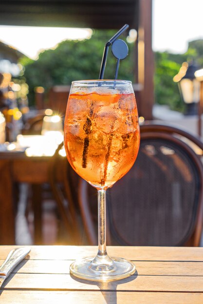 Wine glass of cold cocktail Aperol spritz on table