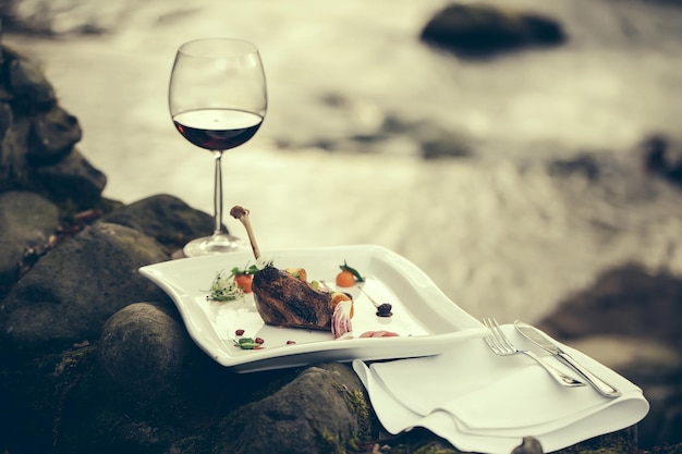 Wine glass and meal near water