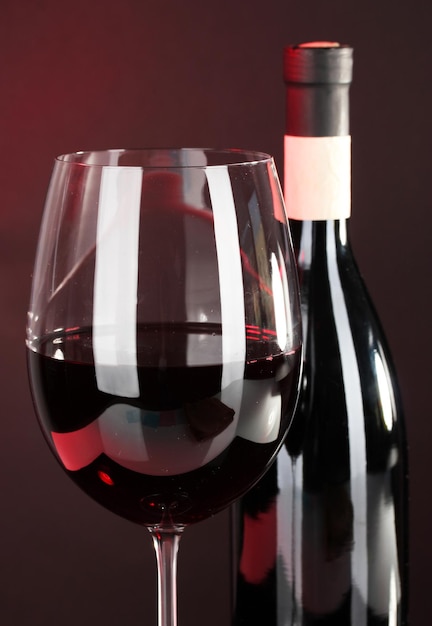 Wine in glass and wine bottle closeup on dark background