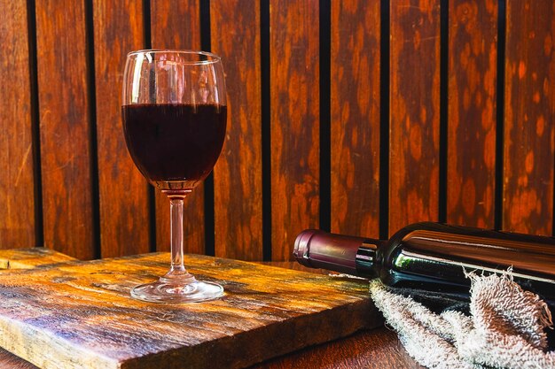 Wine glass and wine bottle on the wooden table