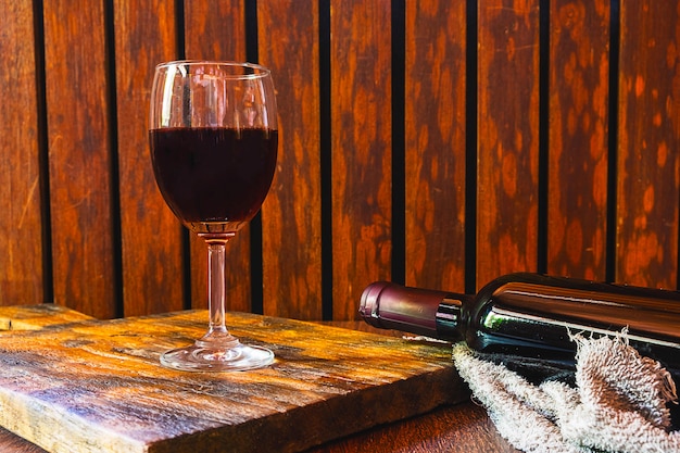 Wine glass and wine bottle on the wooden table