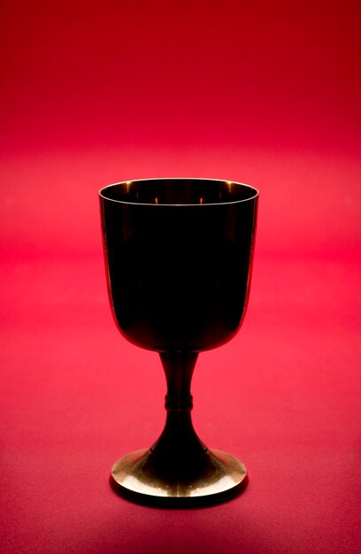 Photo a wine glass with a red background in the background.