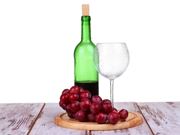 Bicchiere di vino con vino rosso, bottiglia di vino e uva isolato su sfondo bianco