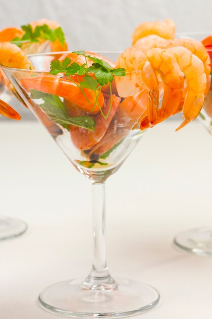 Wine glass with shrimp and herbs.