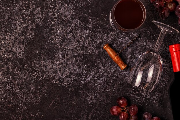 Foto vino, bicchieri, uva e cavatappi su pietra