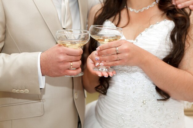 Wine glasses in hand bride and groom.