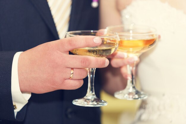 Wine glasses in hand bride and groom.