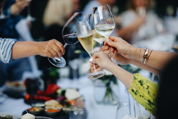 Wine glasses in hands of people at party. High quality photo