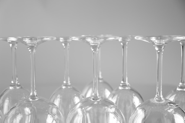 Wine glasses in a row upside down on light grey background