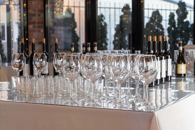 Wine glasses stand on a table in a row catering In the background are beautiful panoramic windows