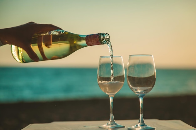 Bicchieri di vino al tramonto sulla spiaggia. messa a fuoco selettiva.