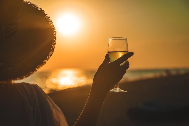 Foto bicchieri di vino al tramonto sulla spiaggia. messa a fuoco selettiva.