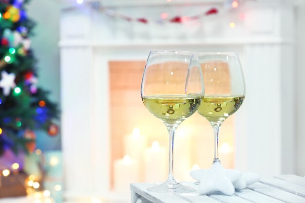 Wine glasses with Christmas decor on fireplace