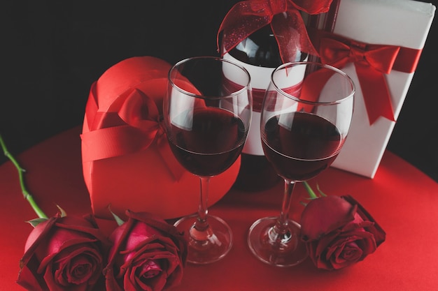Wine glasses with romantic decoration and gifts seen from above