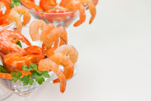 Wine glasses with shrimp and herbs close up. White background.