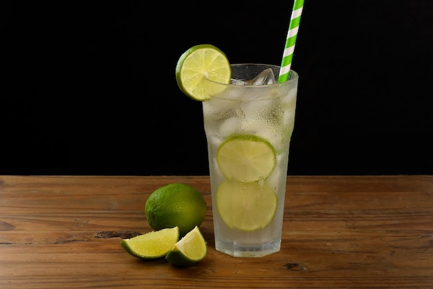 wine limanade, a glass with drink on a wooden board on a black background