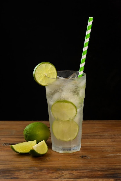 wine limanade, a glass with drink on a wooden board on a black background