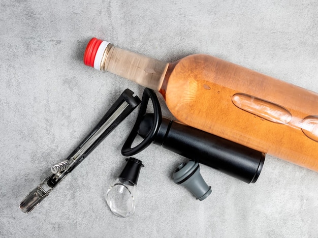 Photo wine opener accessories toolsrose bottle and brie camembert cheese isolated gray tiles backgroundg