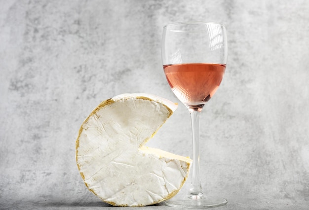 ワインオープナーアクセサリーツールローズボトルとブリーカマンベールチーズ分離グレータイル背景g